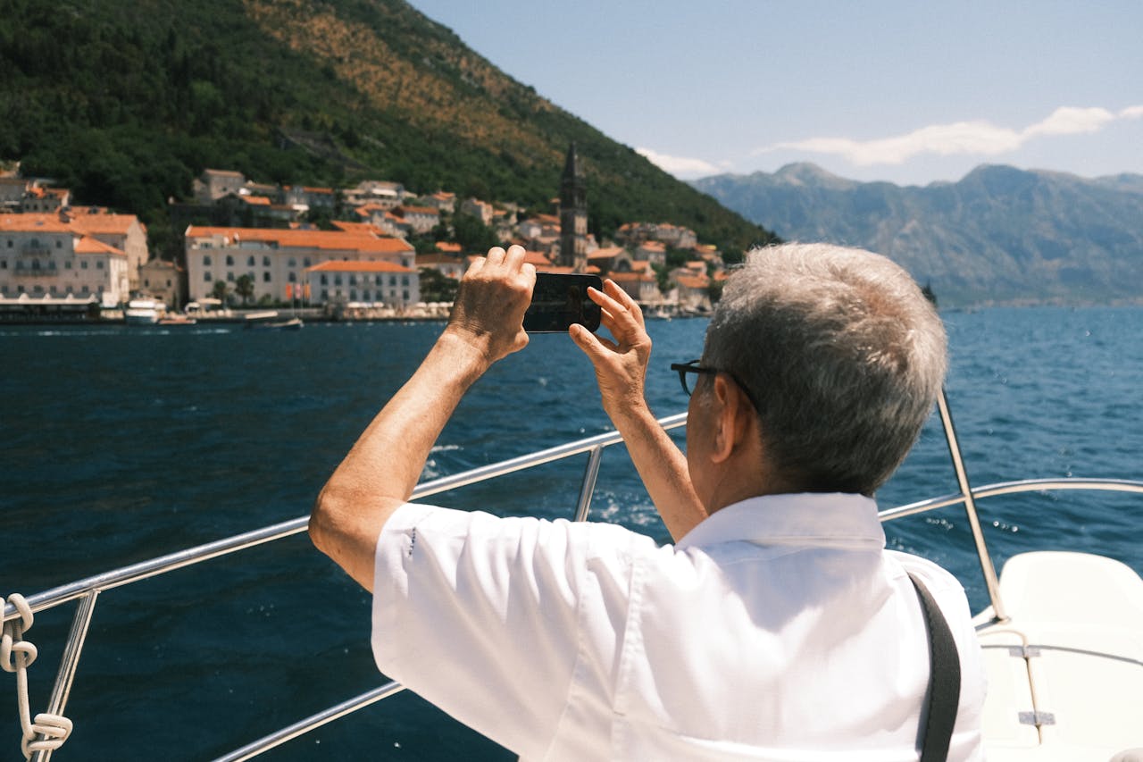 services-01 Adult capturing Perast's stunning architecture and sea view from a boat tour.