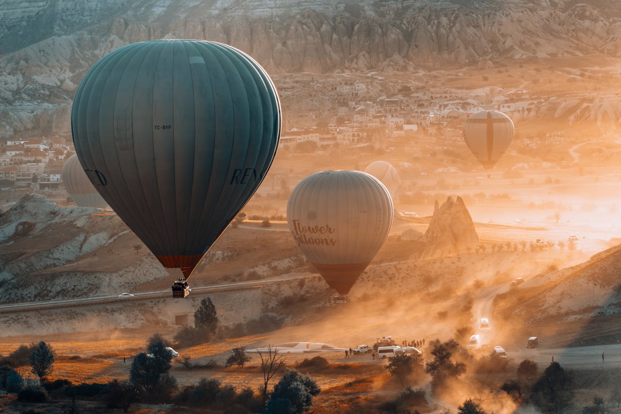 services-04 Majestic hot air balloons soaring over Cappadocia's unique landscape during sunrise, surrounded by warm golden tones.