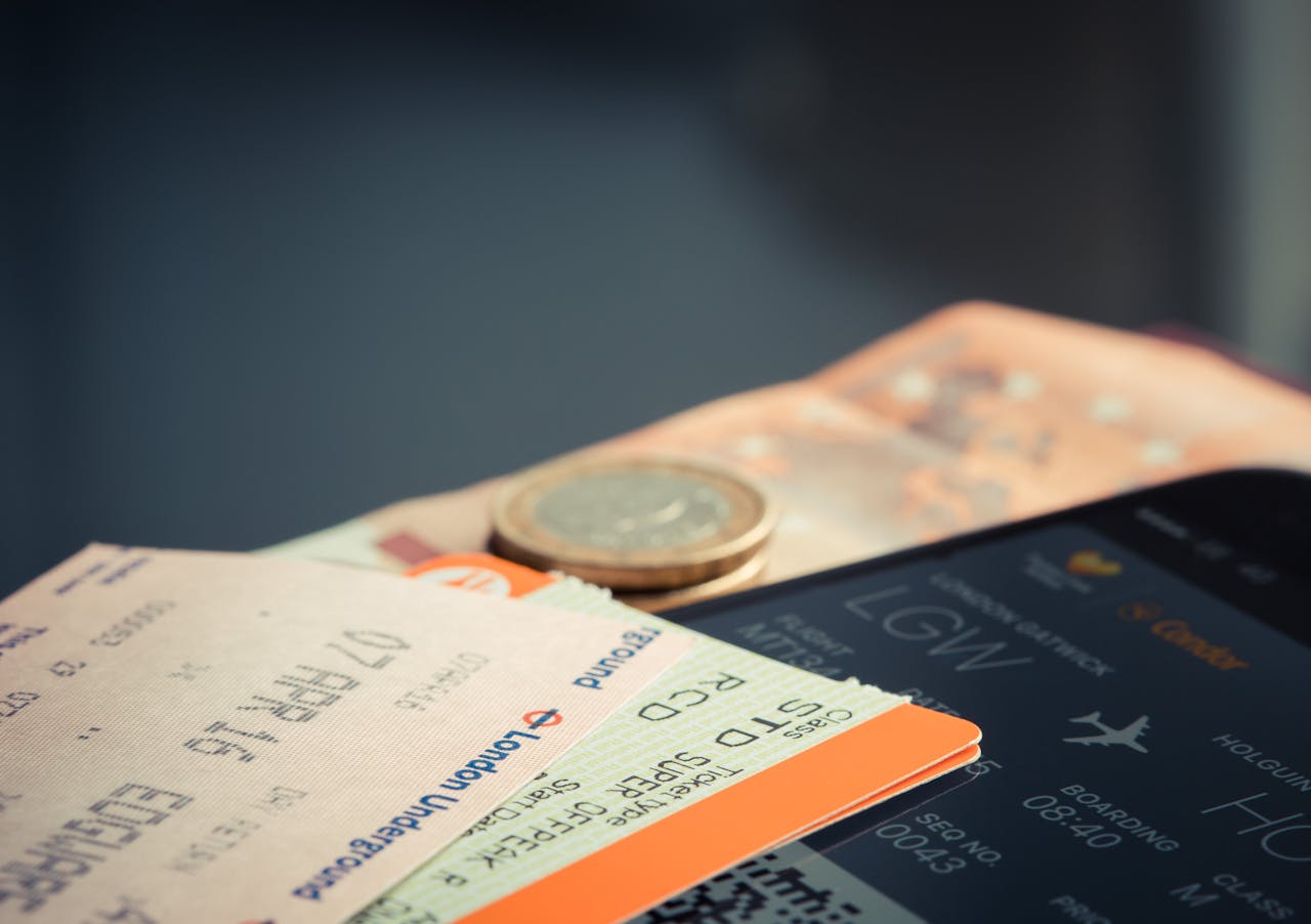 Home Airline ticket with euro coins and smartphone displaying flight details.
